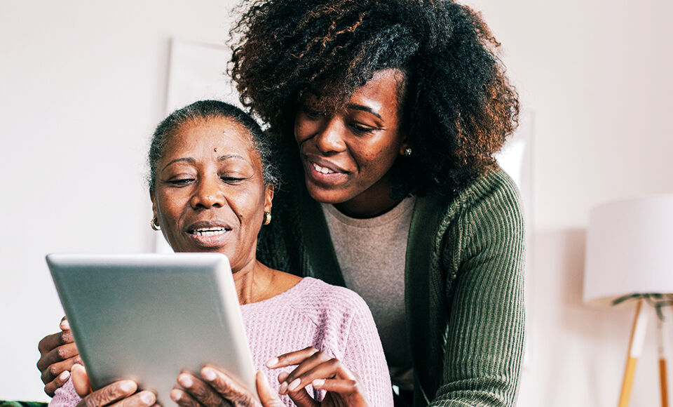 jeune femme aidant sa mère a travailler sur une tablette